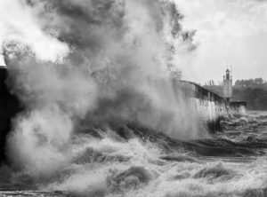 Vague éclatant sur le Môle des Noires à Saint-Malo en noir et blanc, photographie marine bretonne.