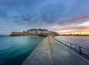 Lever de soleil sur le Môle des Noires et la cité corsaire de Saint-Malo, photographie marine bretonne.